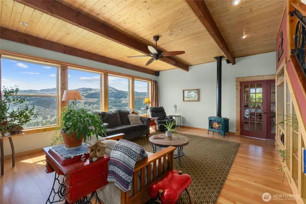 a living room with furniture a rug potted plant and a large window