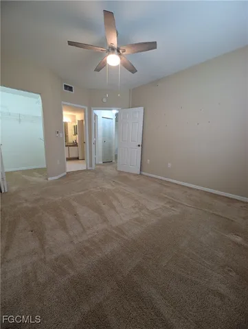 en empty room with windows and fan