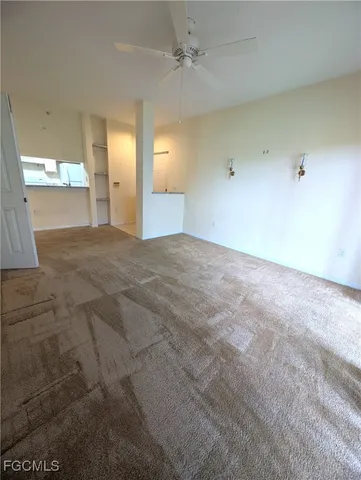 en empty room with windows and a fireplace