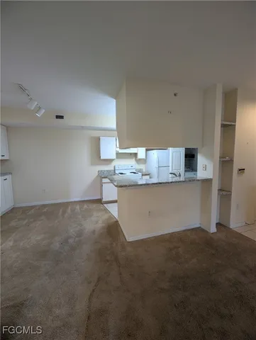 a room with kitchen island stainless steel appliances a sink and a counter top space