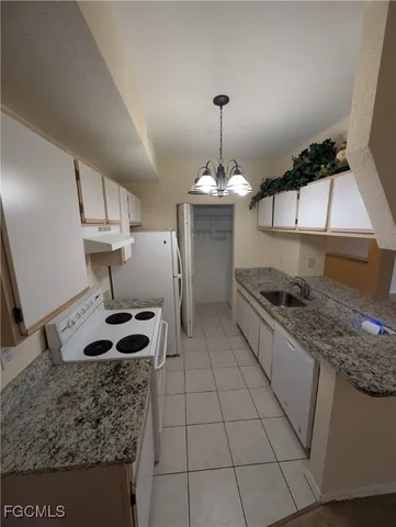 a kitchen with a sink a stove cabinets and a counter top space