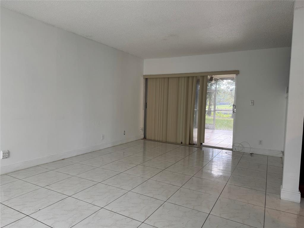 8031 Lagos De Campo Boulevard, Unit L3 Tamarac, FL 33321 - Photo 7 of 26 an empty room with entrance and windows