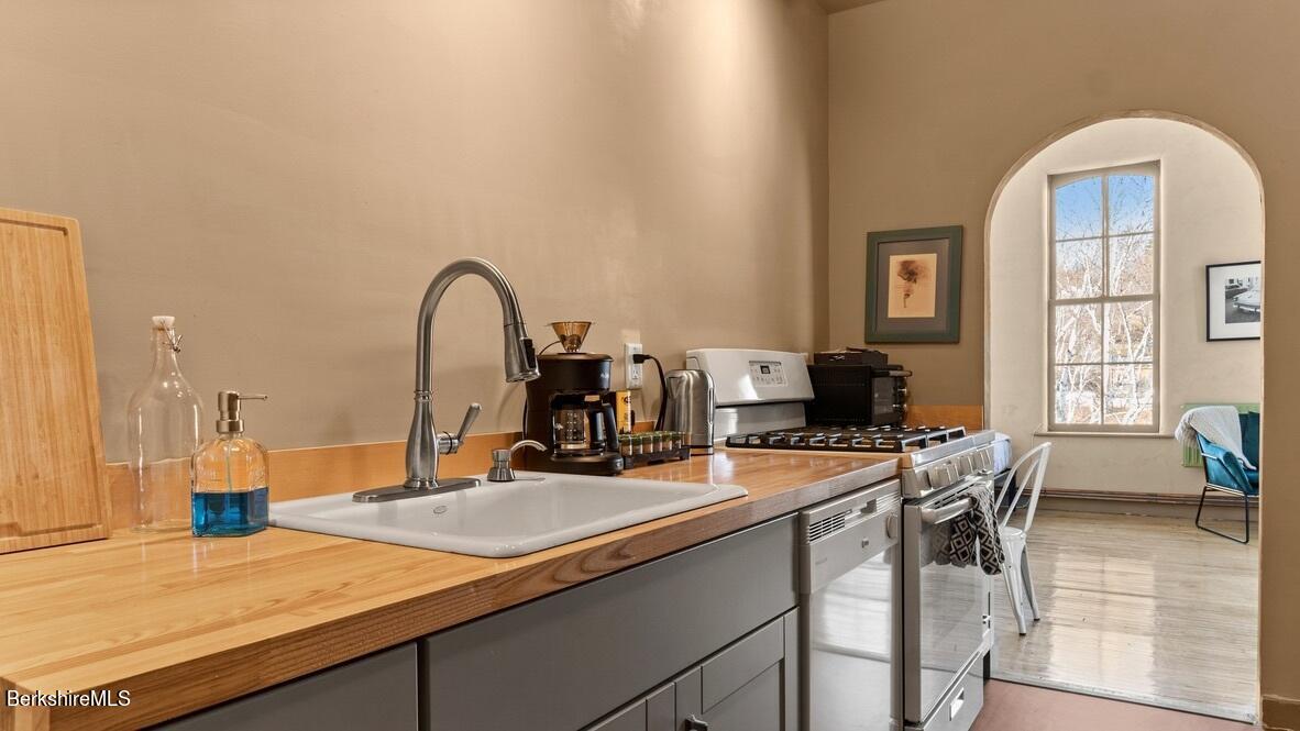 264 Main Street, Unit B Great Barrington, MA 01230 - Photo 18 of 26 a kitchen with a sink a counter and chairs