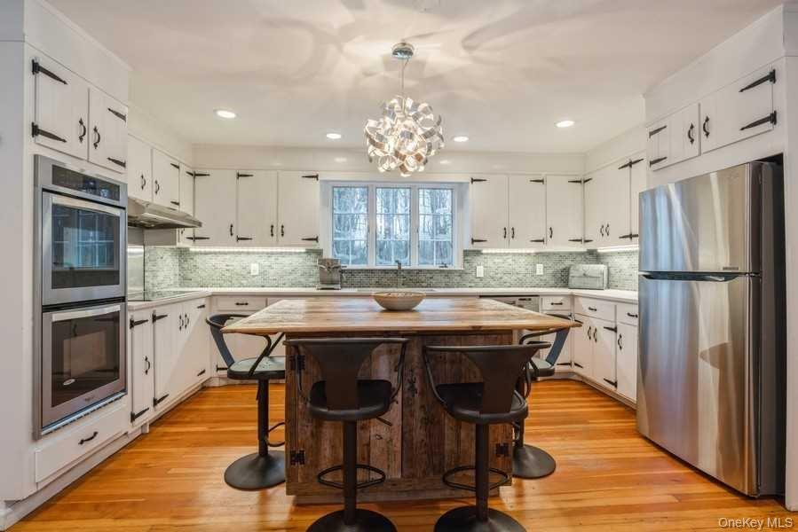 1141 Beekman Road Hopewell Junction, NY 12533 - Photo 4 of 36 a kitchen with stainless steel appliances granite countertop a table chairs refrigerator and microwave