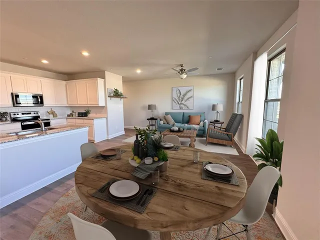 a kitchen with sink refrigerator dining table and chairs
