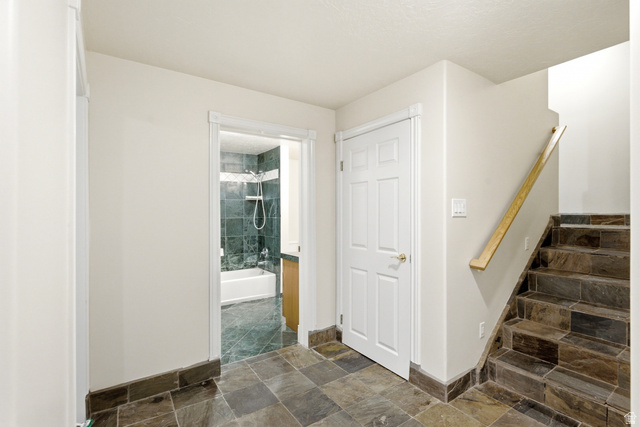 3535 Homestead Road Park City, UT 84098 - Photo 44 of 81 Stone tile flooring with a matching staircase, light wood handrail, and white paneled doors