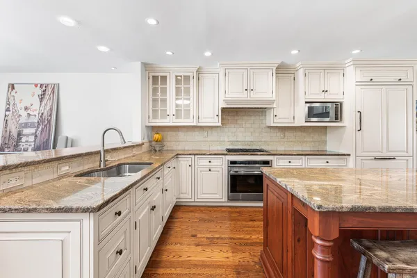 a large kitchen with stainless steel appliances granite countertop a sink and cabinets