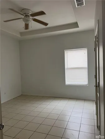 an empty room with a ceiling fan and window