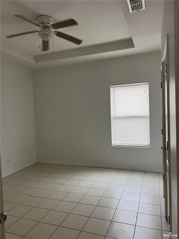 an empty room with a ceiling fan and window