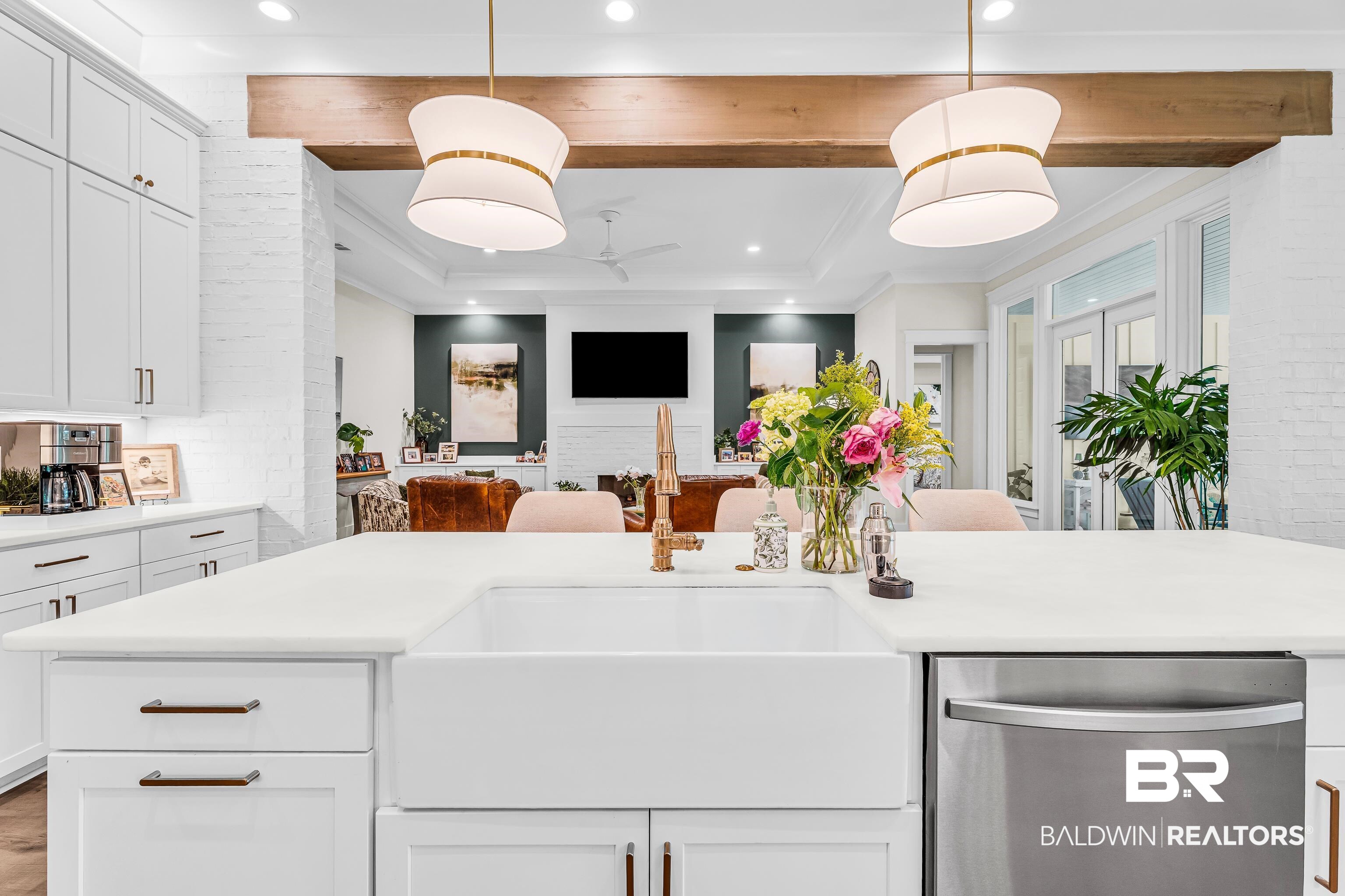 17541 Polo Ridge Boulevard Fairhope, AL 36532 - Photo 5 of 19 Kitchen island featuring an integrated farmhouse sink, a stainless steel dishwasher, and a light-toned countertop