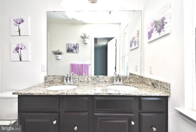 a bathroom with a granite countertop sink and a mirror
