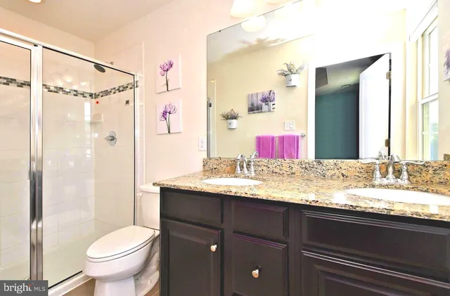a bathroom with a granite countertop sink toilet and shower