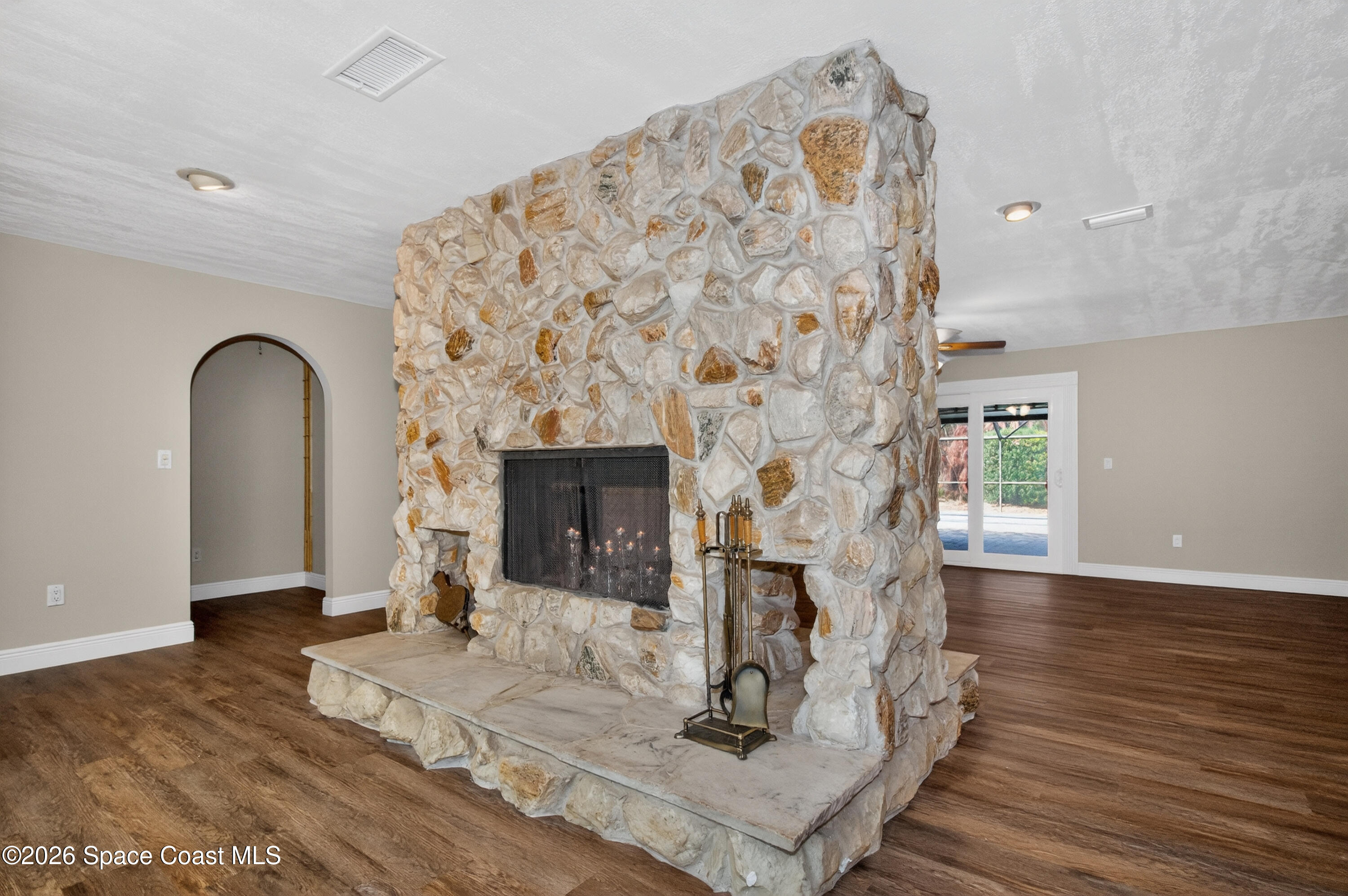 270 Mockingbird Lane Merritt Island, FL 32953 - Photo 4 of 41 a living room with a fireplace with wooden floor