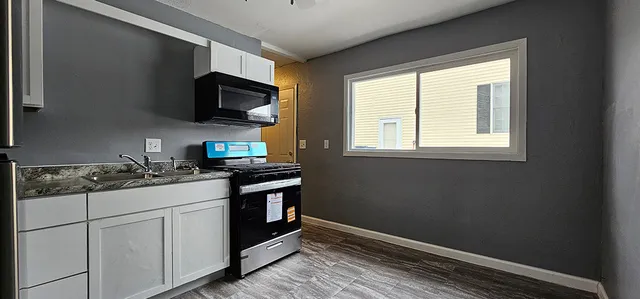 a kitchen with stainless steel appliances granite countertop a stove and a microwave