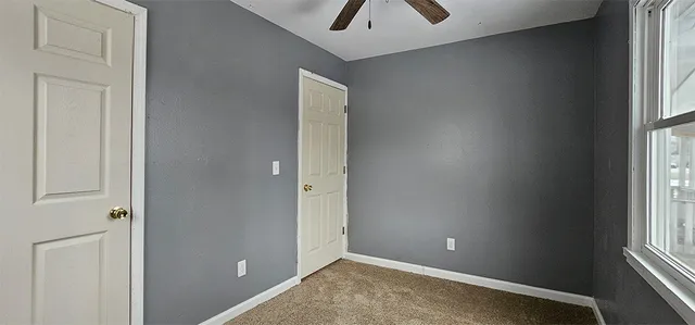 an empty room with windows and closet