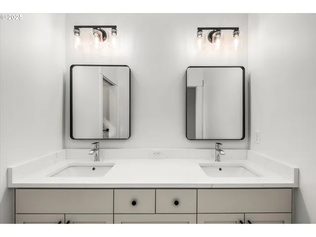 a bathroom with double vanity sinks and a mirror