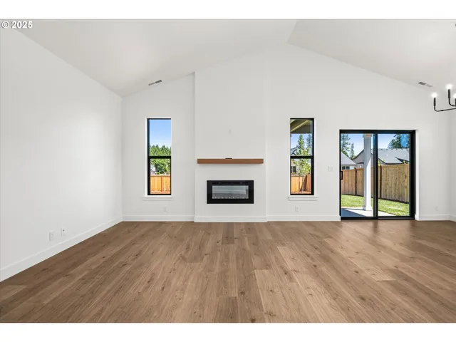 a view of an empty room with a window and fireplace