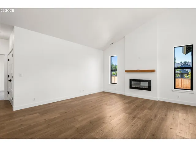 a view of an empty room with window and fire place
