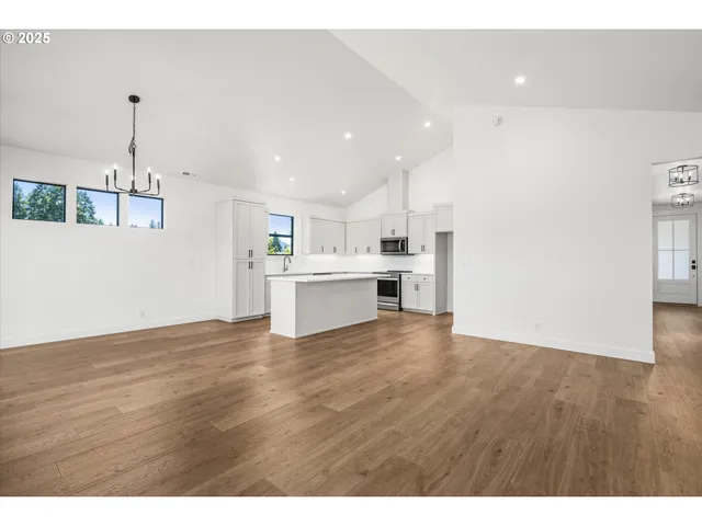 a view of a kitchen with a sink and dishwasher with wooden floor