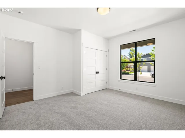 an empty room with windows and closet