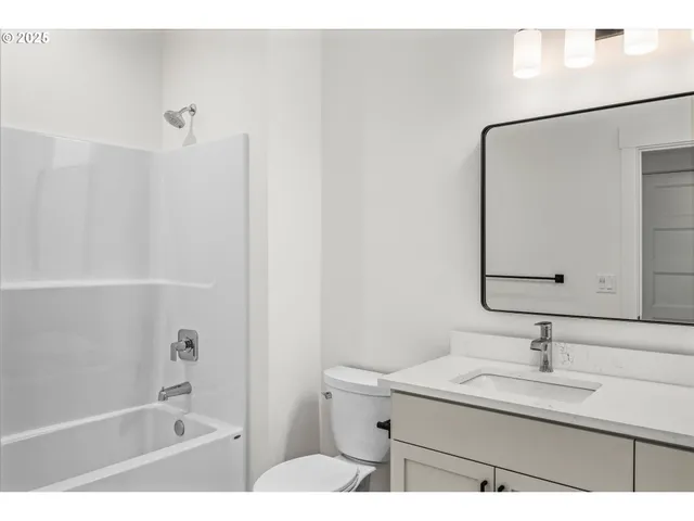 a bathroom with a granite countertop sink mirror and a bathtub