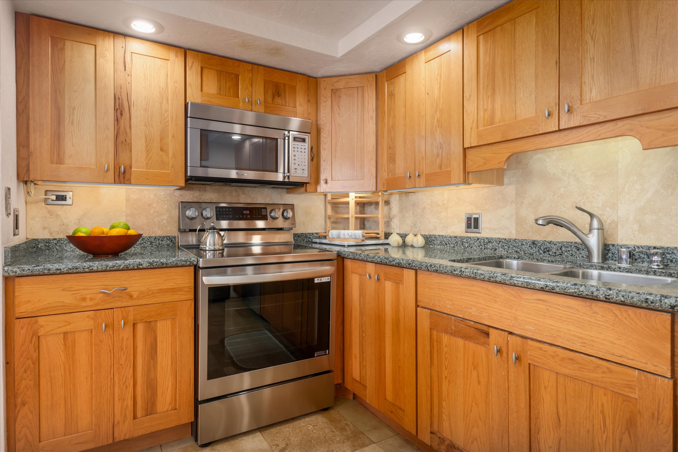 68-1771 Melia Street, Unit G214 Waikoloa, HI 96738 - Photo 12 of 29 a kitchen with granite countertop a sink stove and cabinets