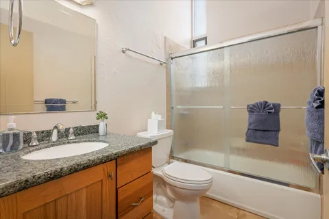 a bathroom with a granite countertop sink toilet and shower