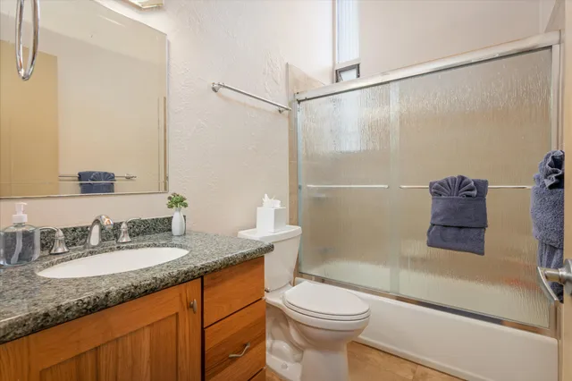 a bathroom with a granite countertop sink toilet and shower