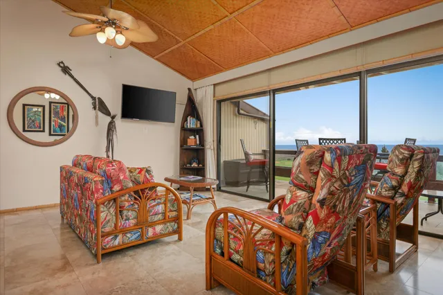 a living room with furniture a flat screen tv and a large window