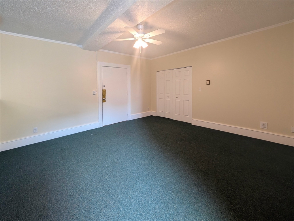 140 Chestnut Street, Unit 207 Springfield, MA 01103 - Photo 4 of 13 an empty room with a ceiling fan and a window