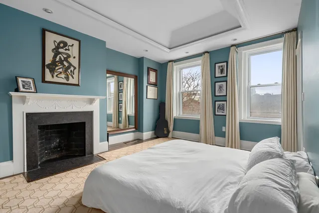 a bedroom with a large bed and a fireplace