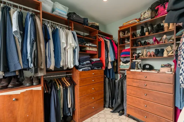 a view of walk in closet with clothes and shoes