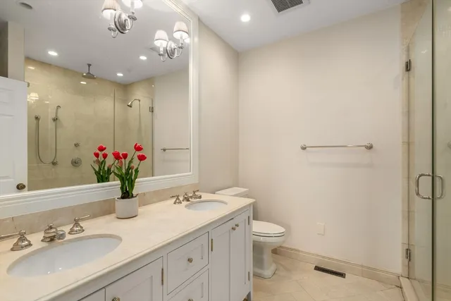 a bathroom with a granite countertop sink a toilet and a mirror