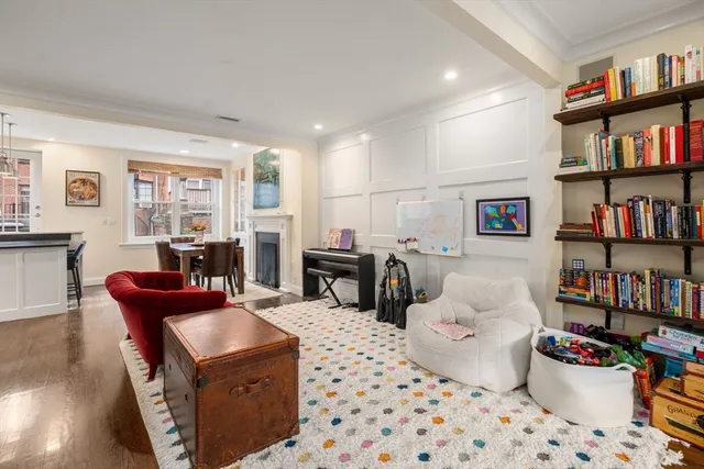 a living room with furniture a bookshelf and a window