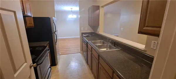 a view of a refrigerator and a stove in a kitchen