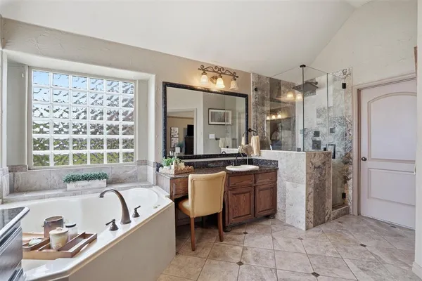 a large bathroom with a tub a sink a mirror and a shower
