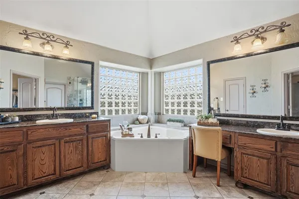 a bathroom with a sink double vanity mirror and a bathtub
