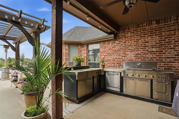 a kitchen with stainless steel appliances granite countertop a sink a stove and cabinets