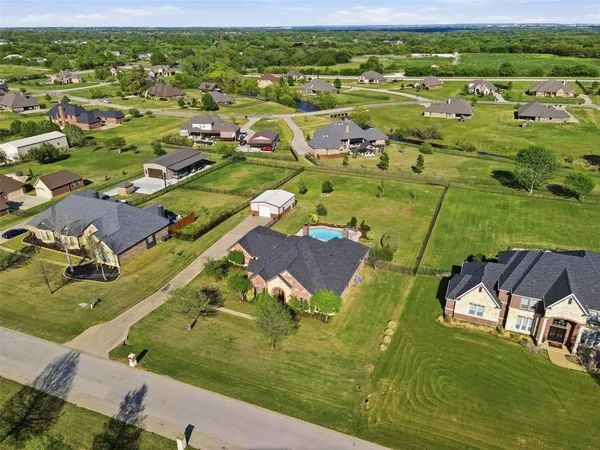 an aerial view of residential houses with outdoor space and a lake view