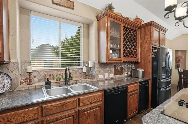 a kitchen with stainless steel appliances granite countertop a sink a stove and a refrigerator