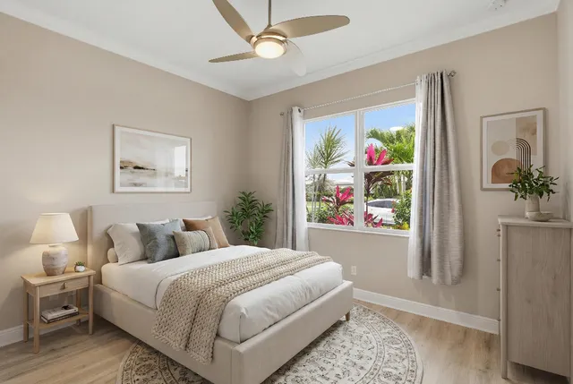 a bedroom with a bed painting on wall and a potted plant