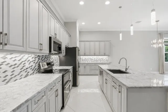 a kitchen with stainless steel appliances granite countertop a sink stove and refrigerator