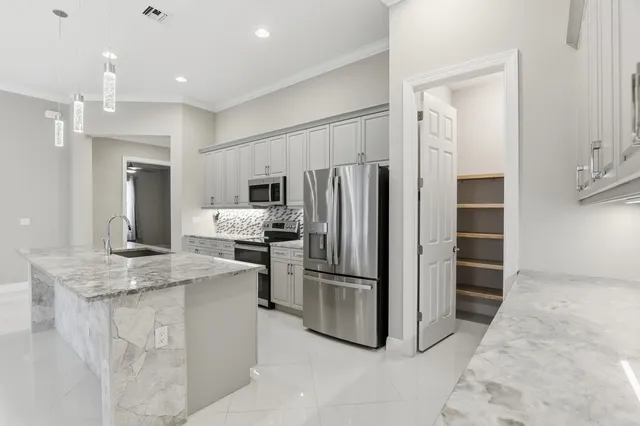 a kitchen with stainless steel appliances granite countertop a refrigerator and a stove top oven