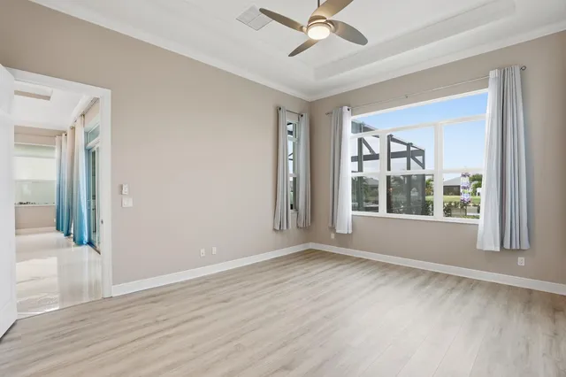 a view of an empty room with a window and wooden floor
