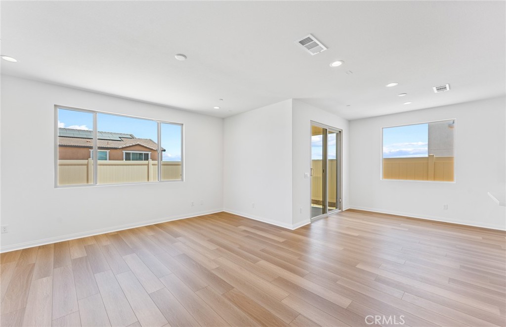 25344 Picket Range Way Menifee, CA 92586 - Photo 6 of 29 an empty room with wooden floor and windows