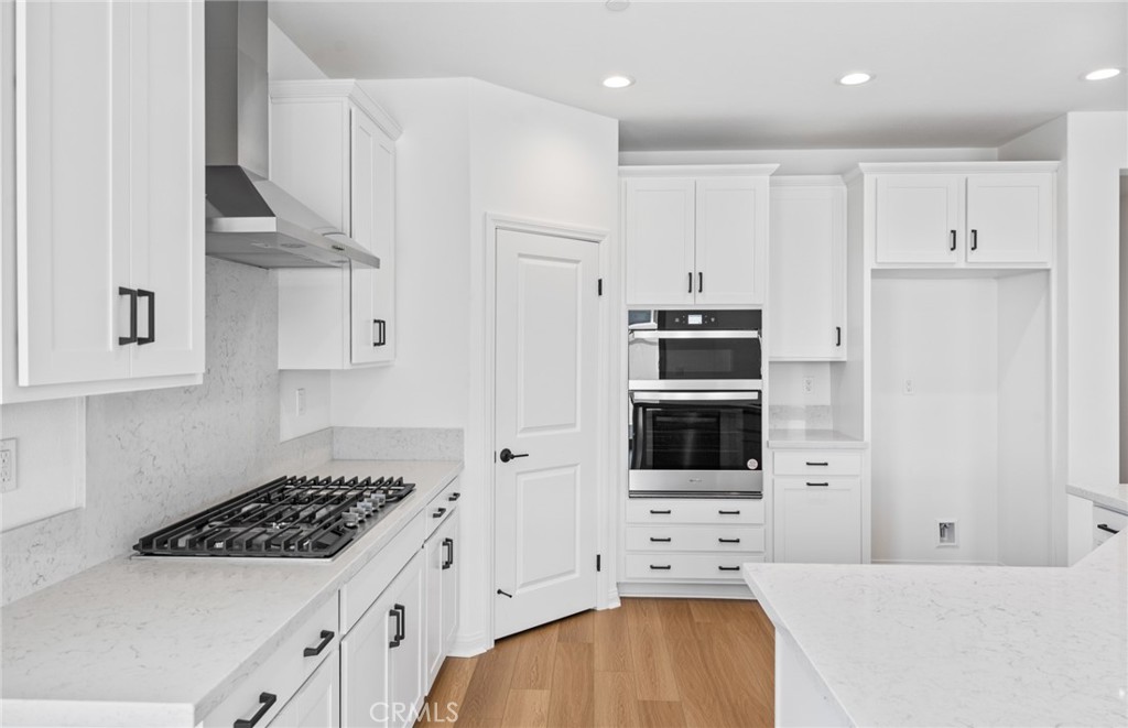 25344 Picket Range Way Menifee, CA 92586 - Photo 9 of 29 a kitchen with stainless steel appliances a stove a microwave and cabinets