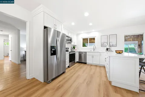 a kitchen with white cabinets and stainless steel appliances
