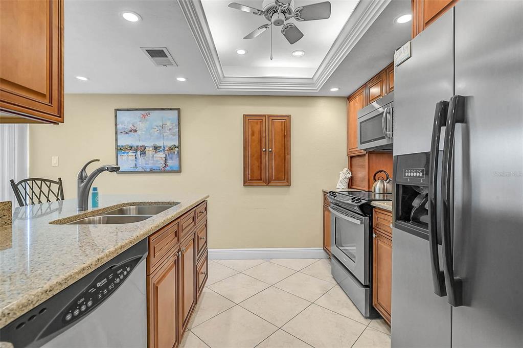 6518 Midnight Pass Road, Unit 407 Sarasota, FL 34242 - Photo 12 of 48 a kitchen with stainless steel appliances granite countertop a sink stove and refrigerator