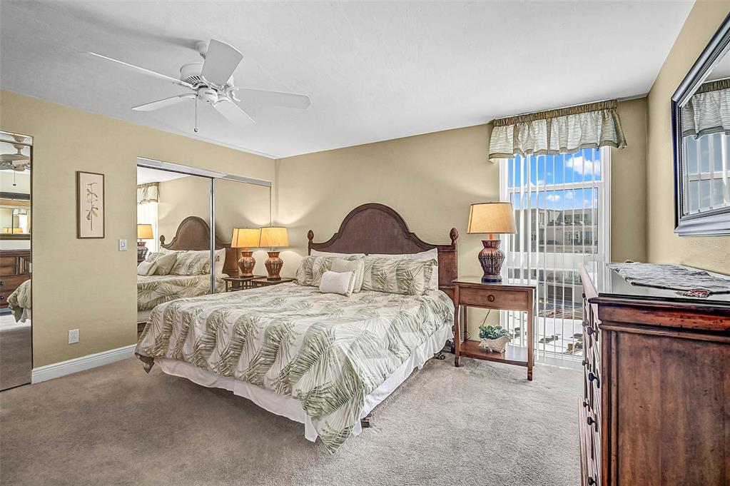 6518 Midnight Pass Road, Unit 407 Sarasota, FL 34242 - Photo 18 of 48 a bedroom with a bed and wooden floor