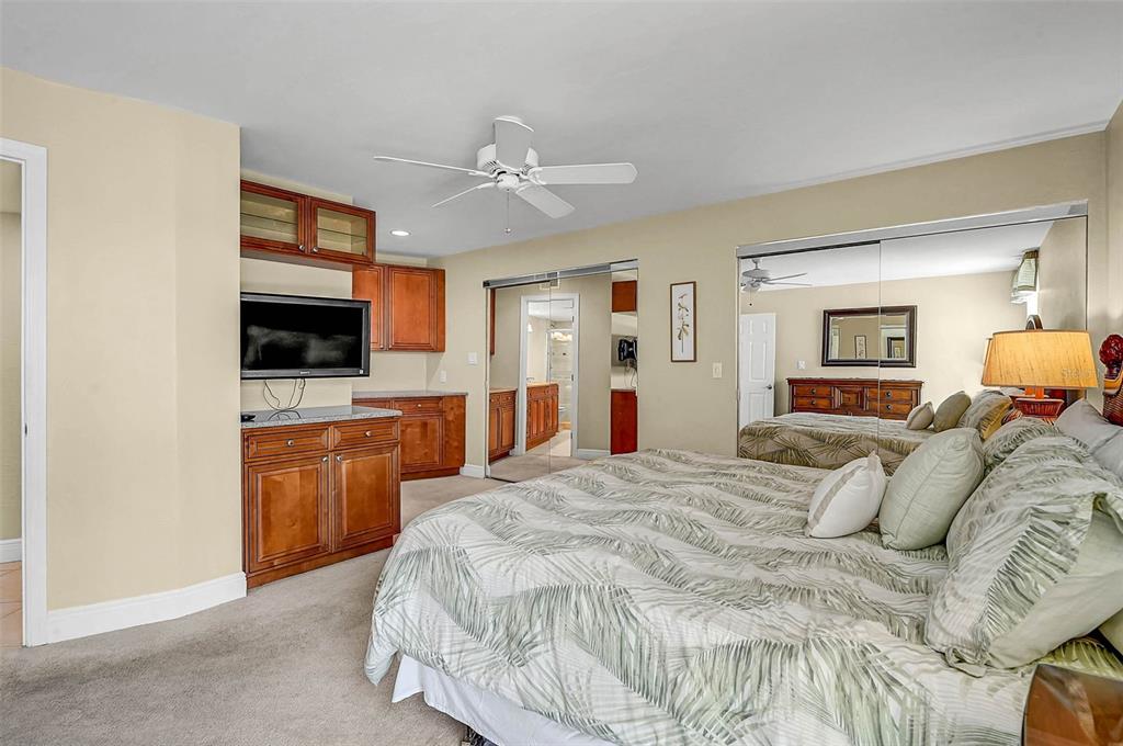6518 Midnight Pass Road, Unit 407 Sarasota, FL 34242 - Photo 19 of 48 a bed room with a bed a television and dresser